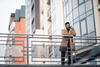 a man leaning on a causeway railing talking on his mobile phone